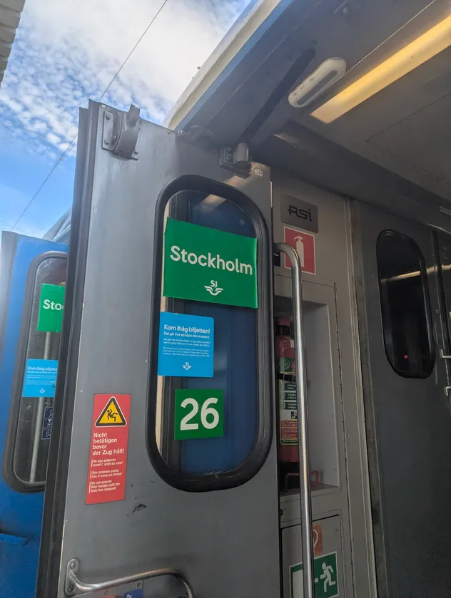 train door opened with sj's logo & stockholm written on it